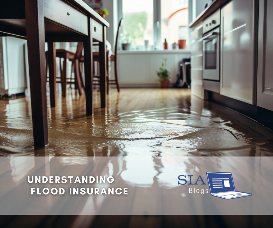 This image shows a flooded kitchen, with water covering the floor and reflecting the furniture above. The caption overlay reads, "Understanding Flood Insurance," along with the SIA Blogs logo.