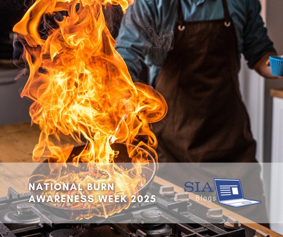 The image shows a person cooking with a pan on a stove that is on fire. The text "National Burn Awareness Week 2025" is displayed at the bottom, along with the SIA Blogs logo in the corner.